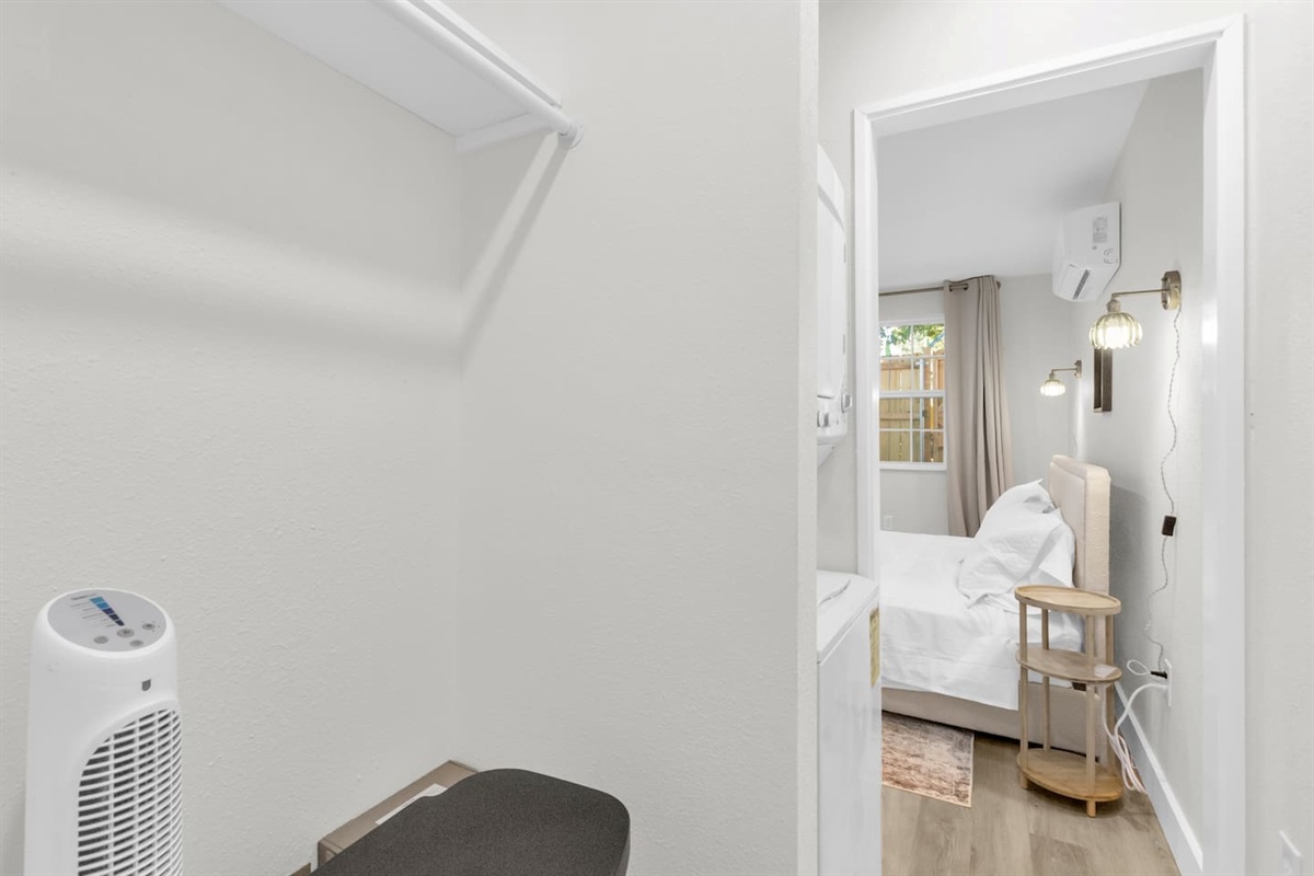 Washer and dryer in unit with extra clothing storage and a portable fan—perfect for long-term stays and added comfort.