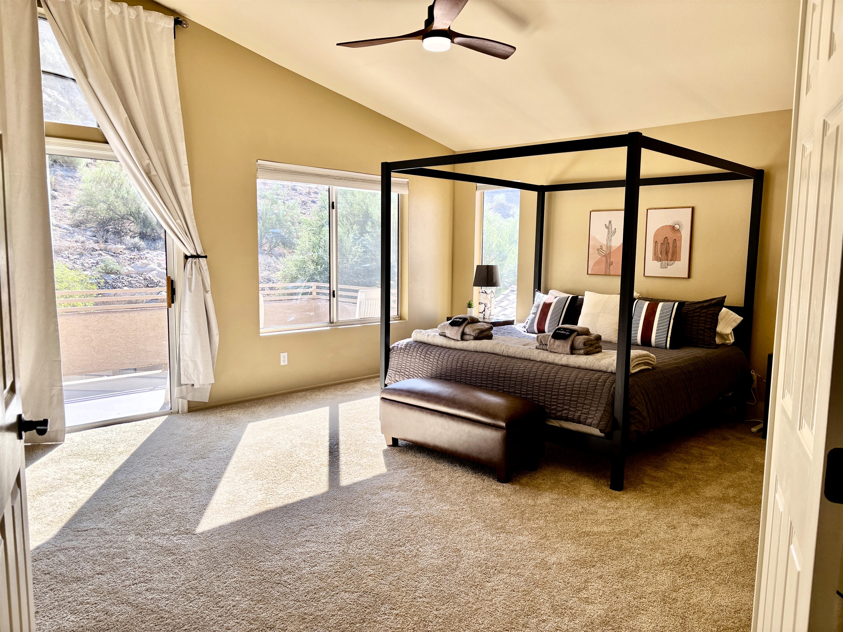 Primary bedroom with ensuite bathroom, Smart TV, walk in closet, private balcony, ceiling fan, linens and remote workstation