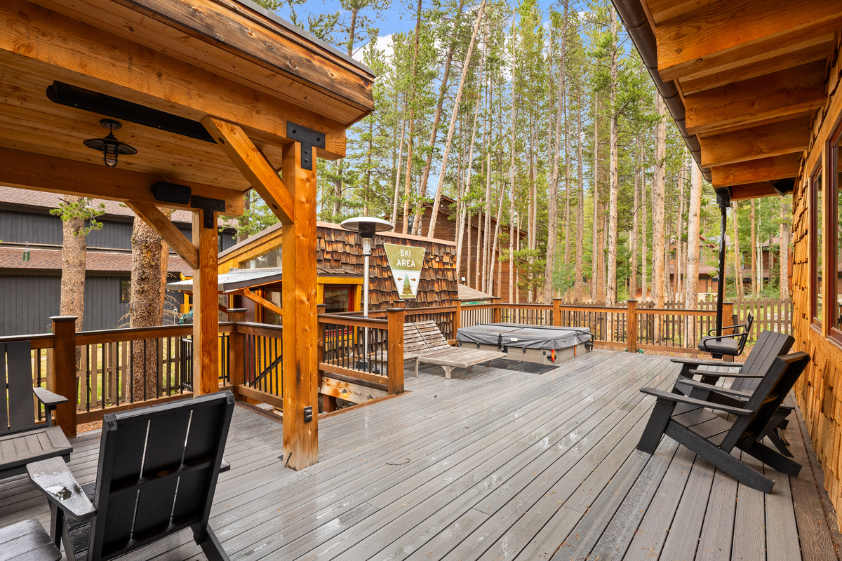 Outdoor living space with lounge seating, in-ground hot tub, and sleeping bungalow. 
