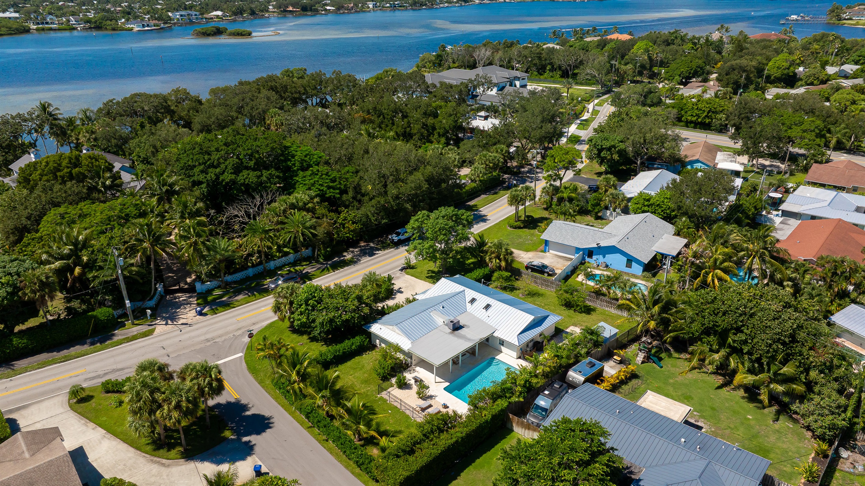 A stunning aerial view captures this luxury coastal retreat with a sparkling pool, manicured lawns, and lush tropical landscaping - offering the perfect blend of privacy, sophistication, and resort-style living just minutes from the beach.
