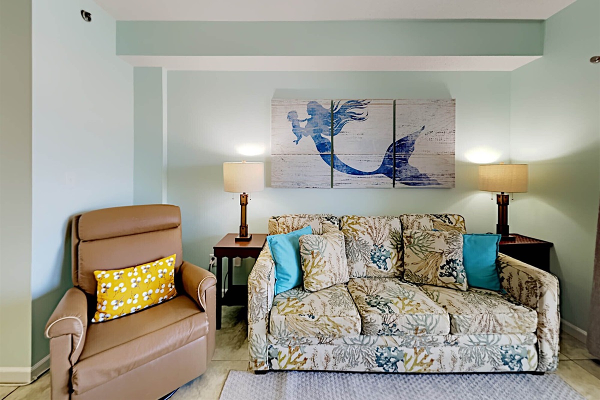 Living room with sleeper sofa, smart TV, recliner, ceiling fan and balcony access