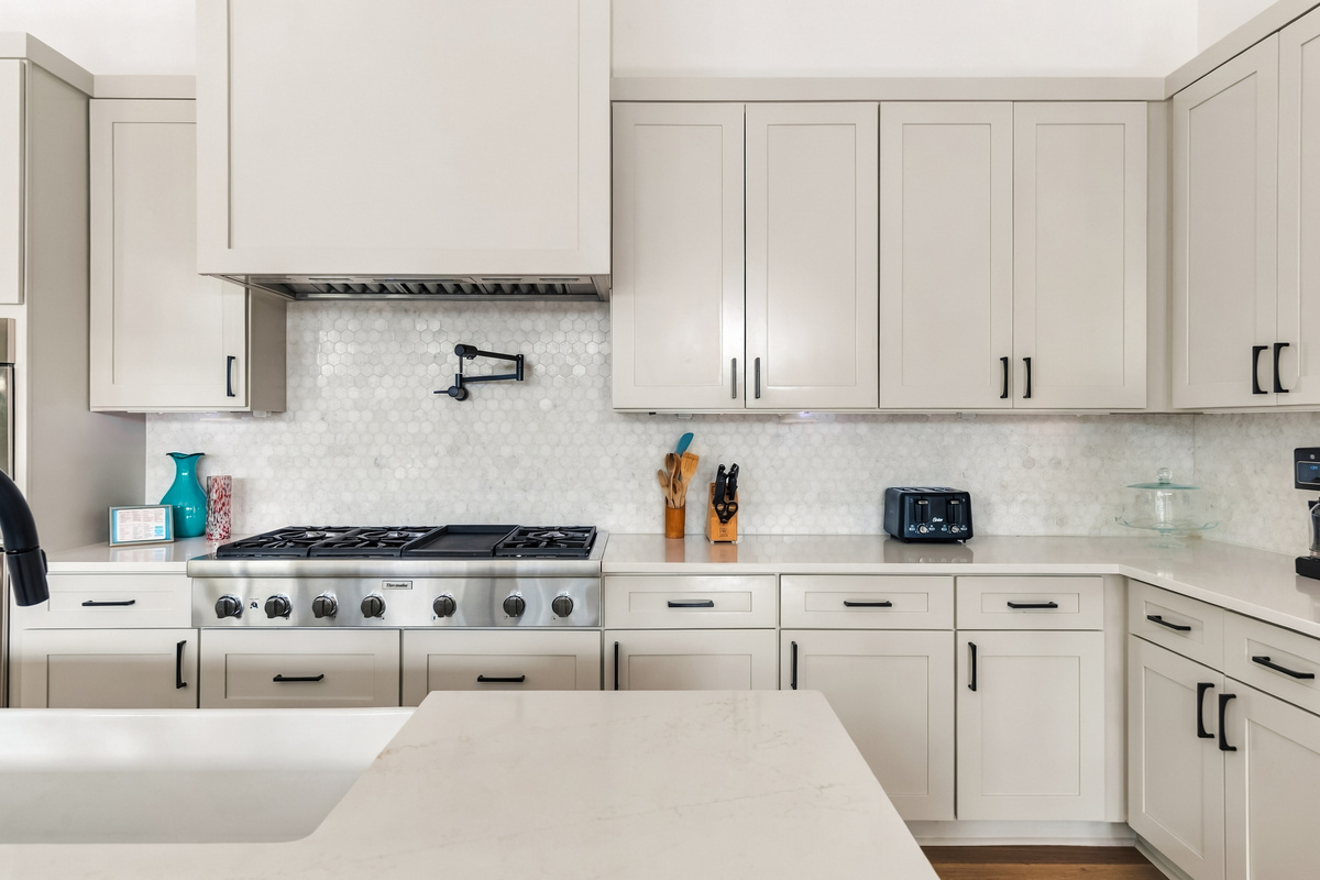 Spacious quartz counters and a stainless range hood complete the kitchen.