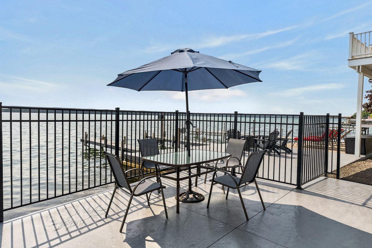 Fenced patio seating under a large umbrella