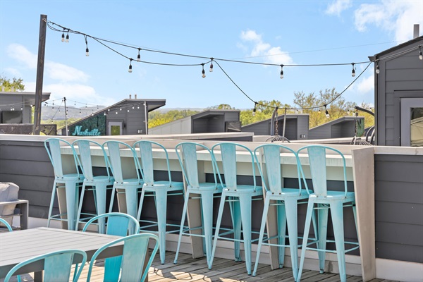 Rooftop Oasis: Sip cocktails at the bar with stunning views and twinkling string lights!