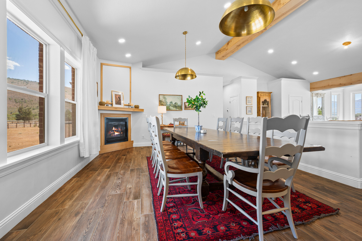 Enjoy long, relaxed meals beside the glowing fireplace, surrounded by mountain views, exposed wood beams, and elegant brass lighting that gives the space a refined yet welcoming atmosphere.