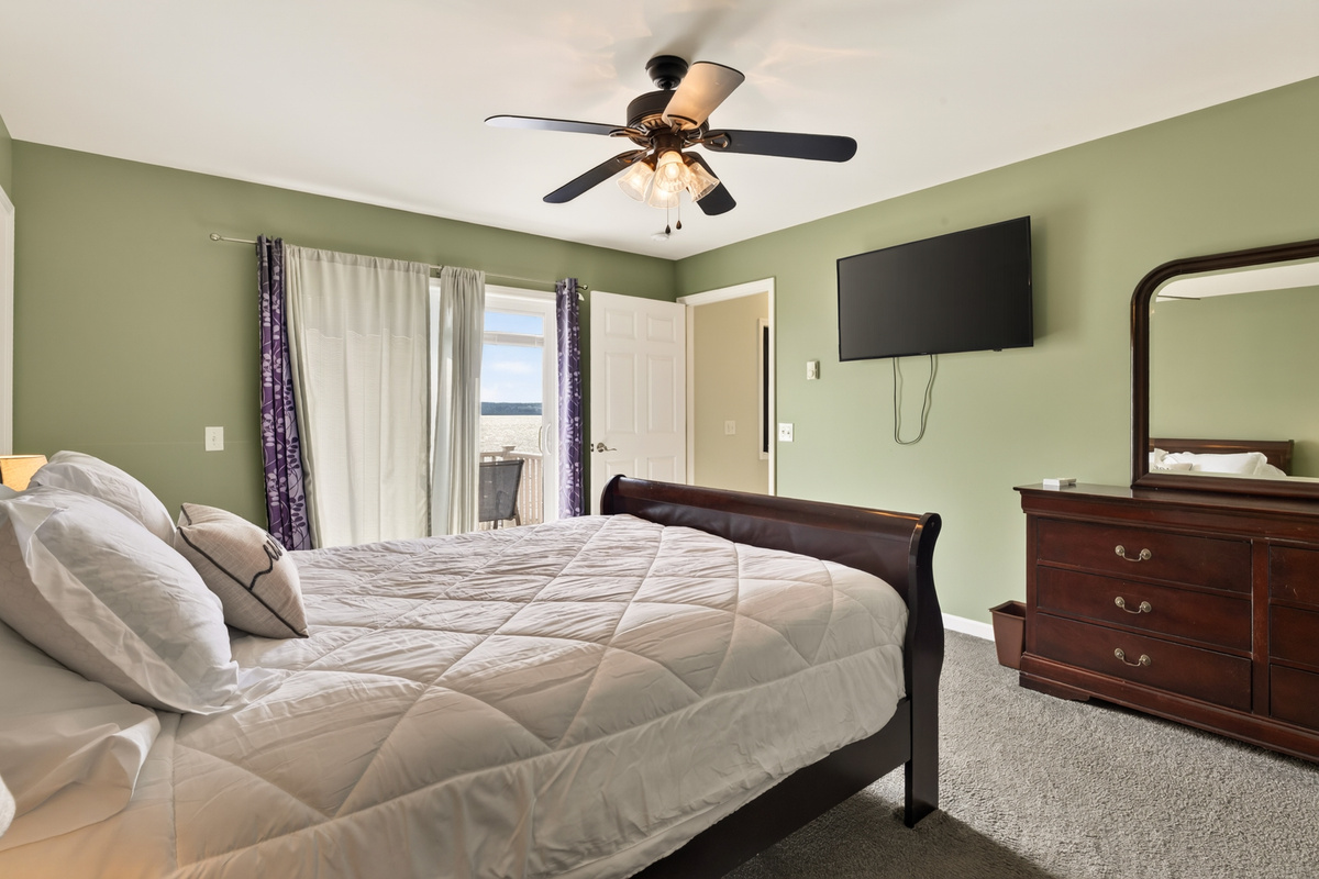 Bedroom with dresser and wall-mounted television
