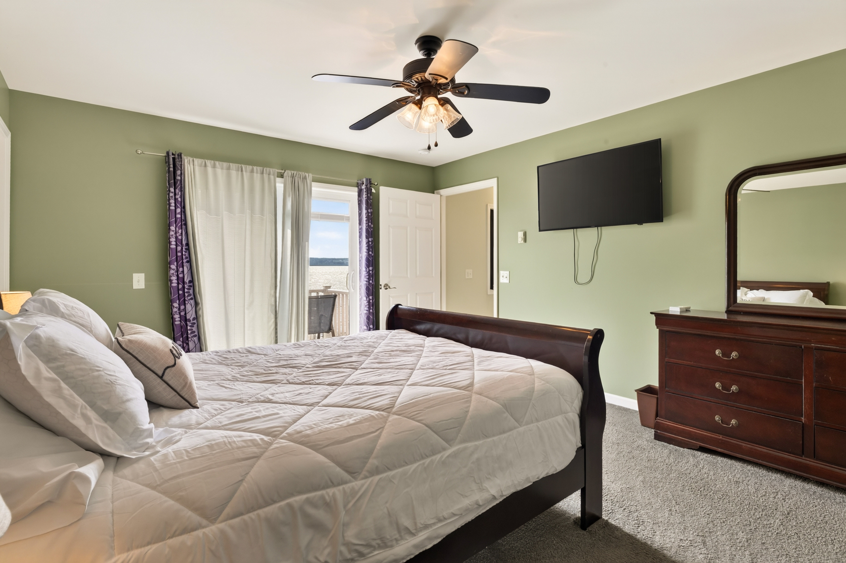 Bedroom with dresser and wall-mounted television
