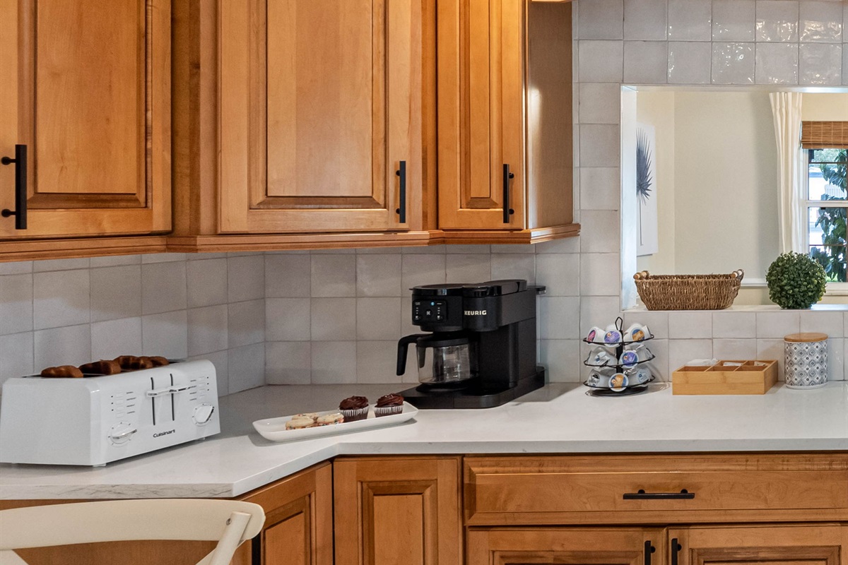 Natural wood cabinets and white quartz countertops create a timeless and inviting kitchen design.