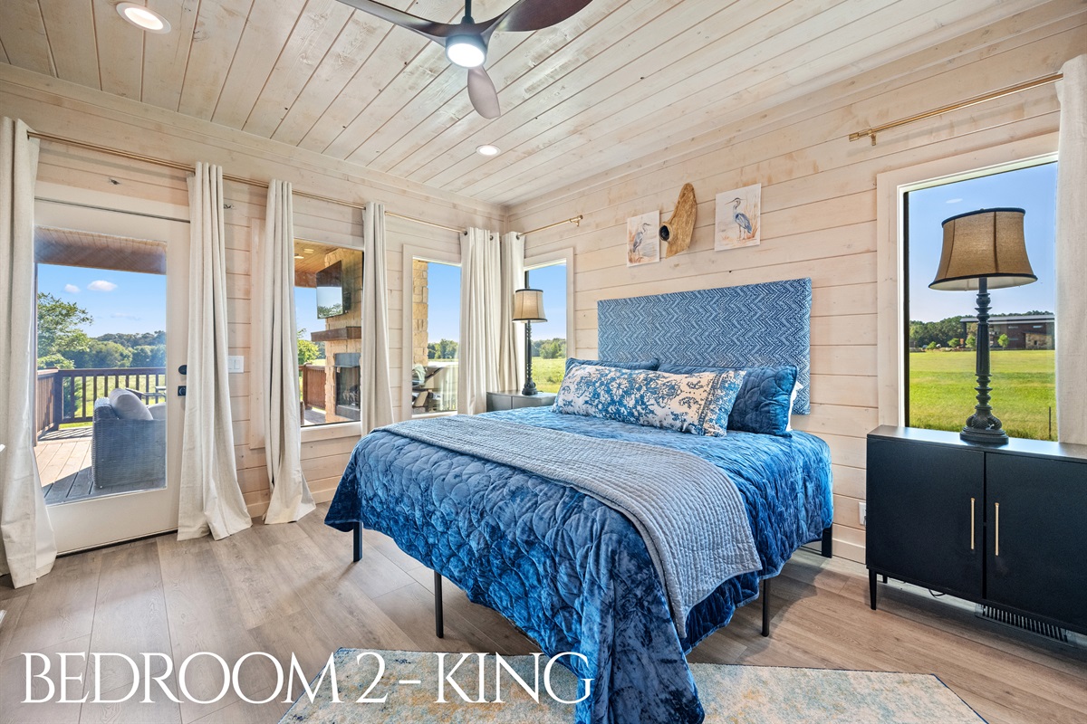 Bedroom 2 with king bed and large windows offering countryside views.