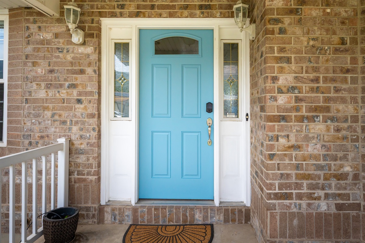 Charming front entrance featuring a cheerful blue door and smart lock entry for easy self check-in.