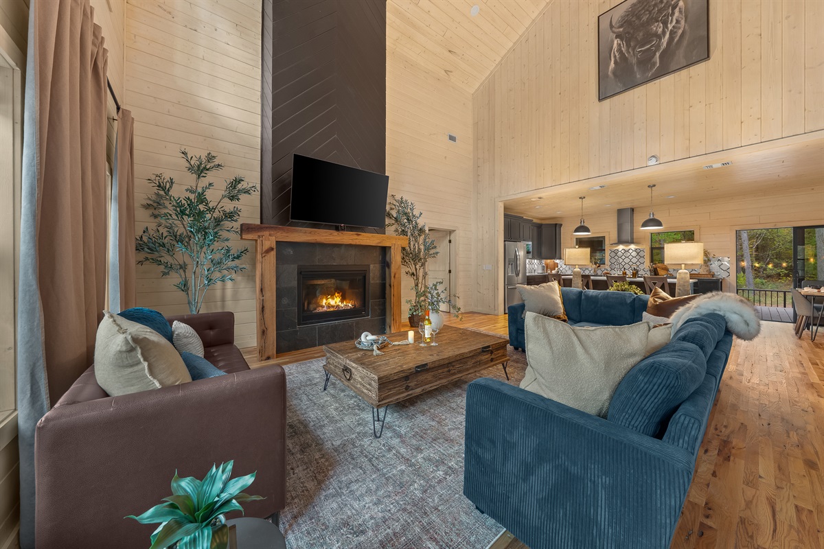 Open concept living room with a dramatic fireplace, plush seating, and easy flow into the kitchen and dining area.