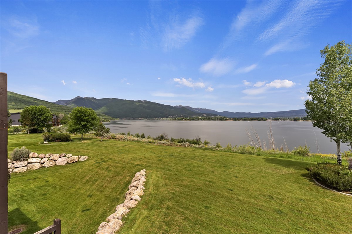 Expansive lawn rolling toward the lake creates a peaceful, open setting just steps from the shoreline.