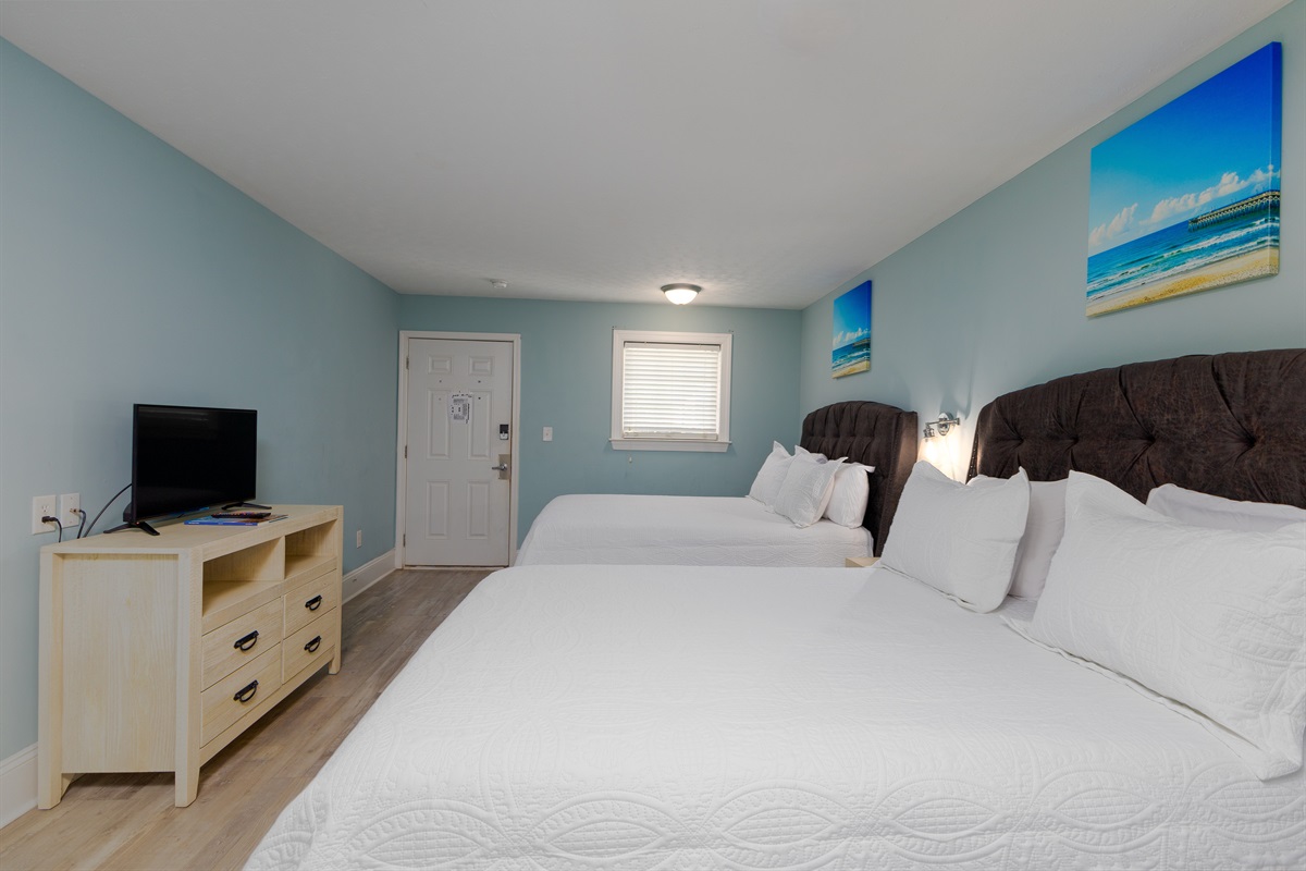 A flat-screen TV and dresser complete the space