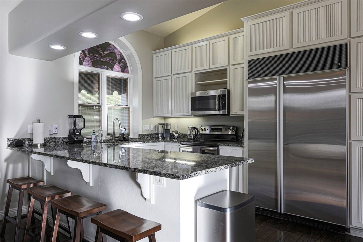 This chef’s kitchen blends modern utility with upscale charm—featuring granite countertops, premium stainless steel appliances, and a spacious breakfast bar perfect for casual bites or morning coffee.