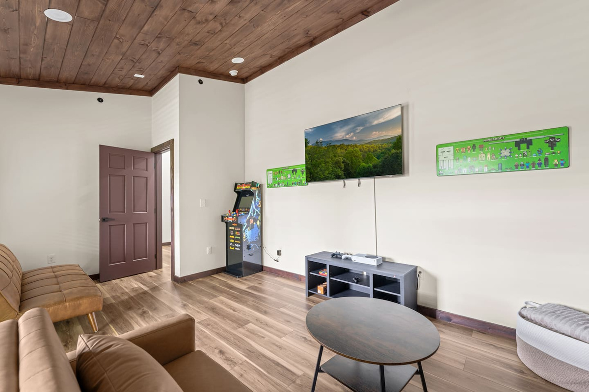game room with xbox gaming system and also a arcade style gaming system, with 2 sleeping sofas