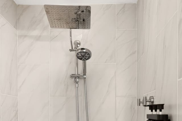 The walk in shower features a rainfall shower head, a hand held shower head and complimentary shampoo, conditioner and body wash.