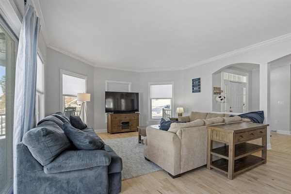 The perfect gathering place - this first-floor living room offers two couches, a big-screen TV, and breathtaking views of the lake.