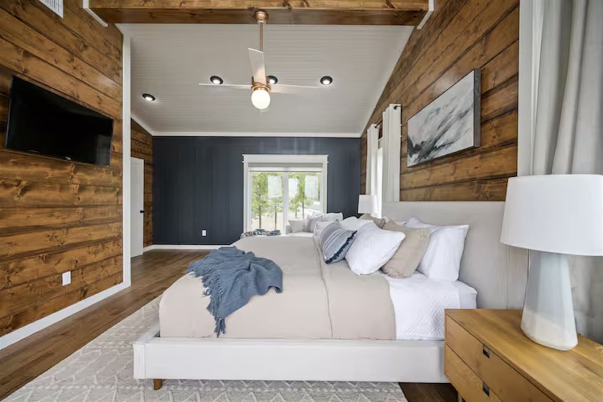 Bedroom with upholstered bed and accent wood walls.