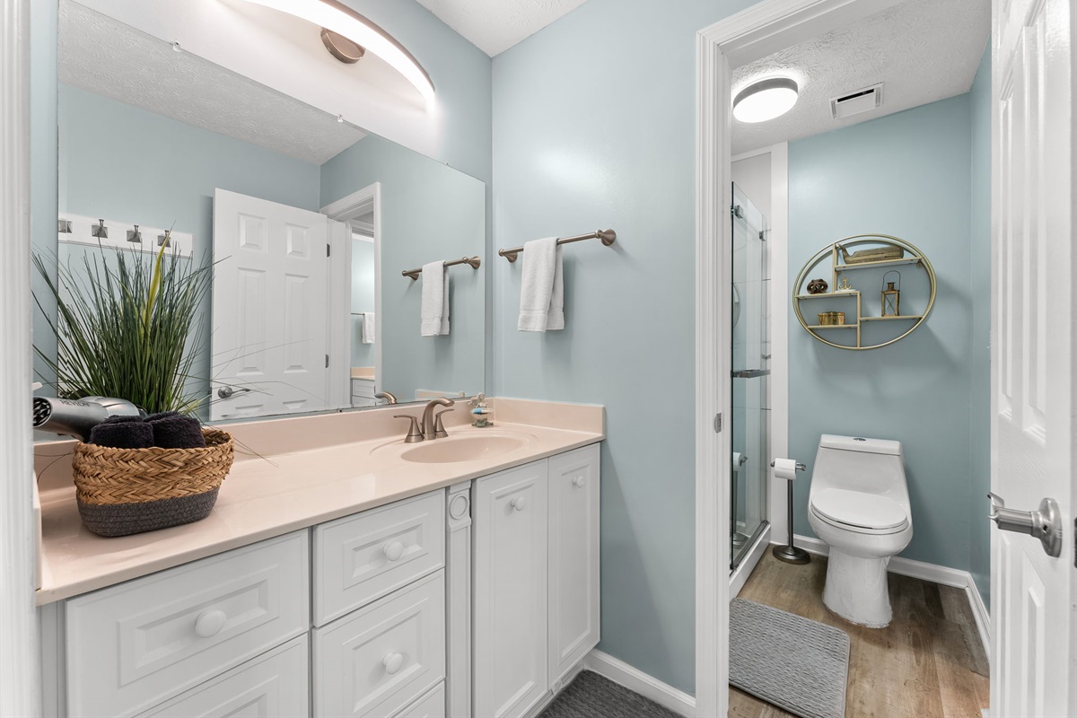 Completely remodeled master shower featuring beautiful tile and a luxurious rain shower head — now conveniently accessible through the hallway half bath.