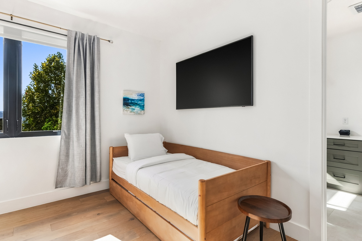 A cozy twin bed nook with mounted TV, tucked in the primary suite.