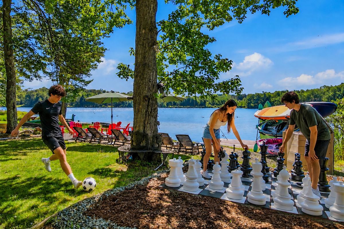 Guests playing giant chess on the lakefront lawn — one of the many ways to spend an afternoon here