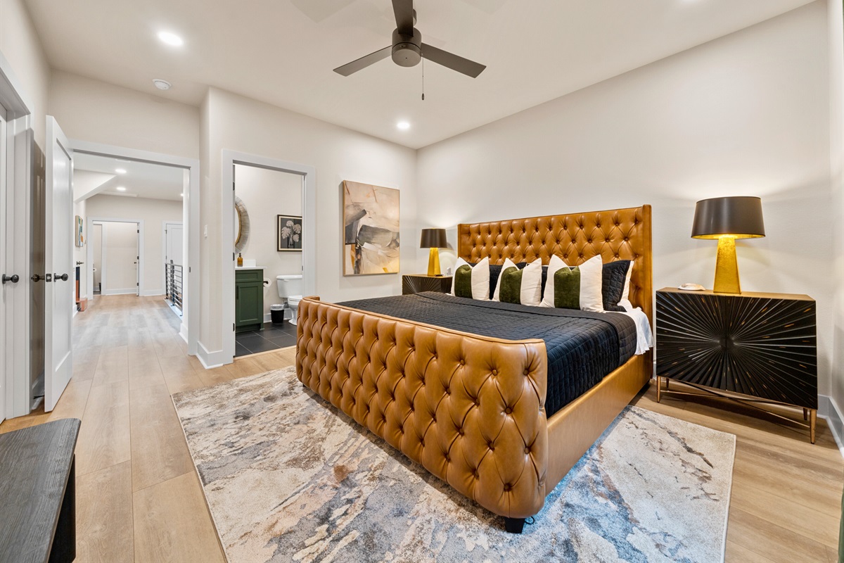 The room's modern decor, featuring rich textures and bold color accents, adds an element of sophistication and style.
