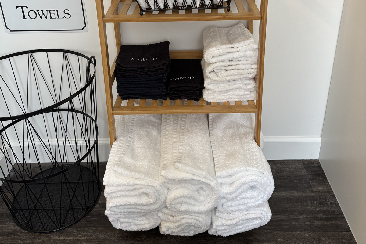 Queen bed is prepared with fresh linens, towels, and guest toiletries.
