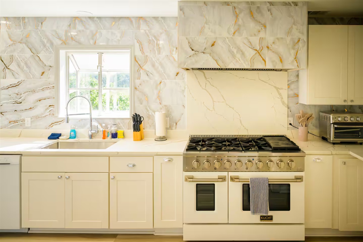 Cook like a pro with this luxury 48” gas range and designer marble backsplash.