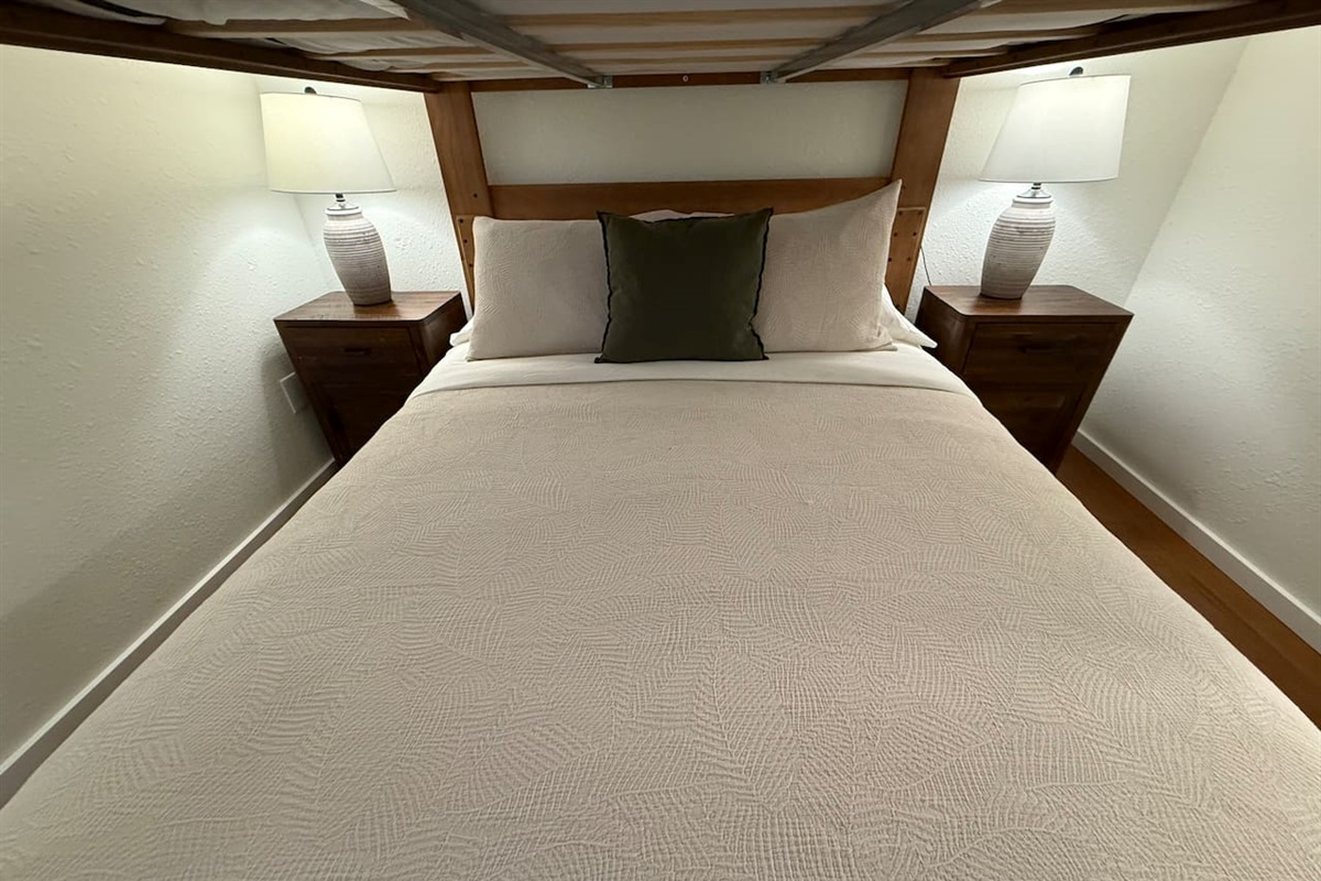 Nightstands with a lamp and electrical outlets and USB outlets on either side of the bed. 