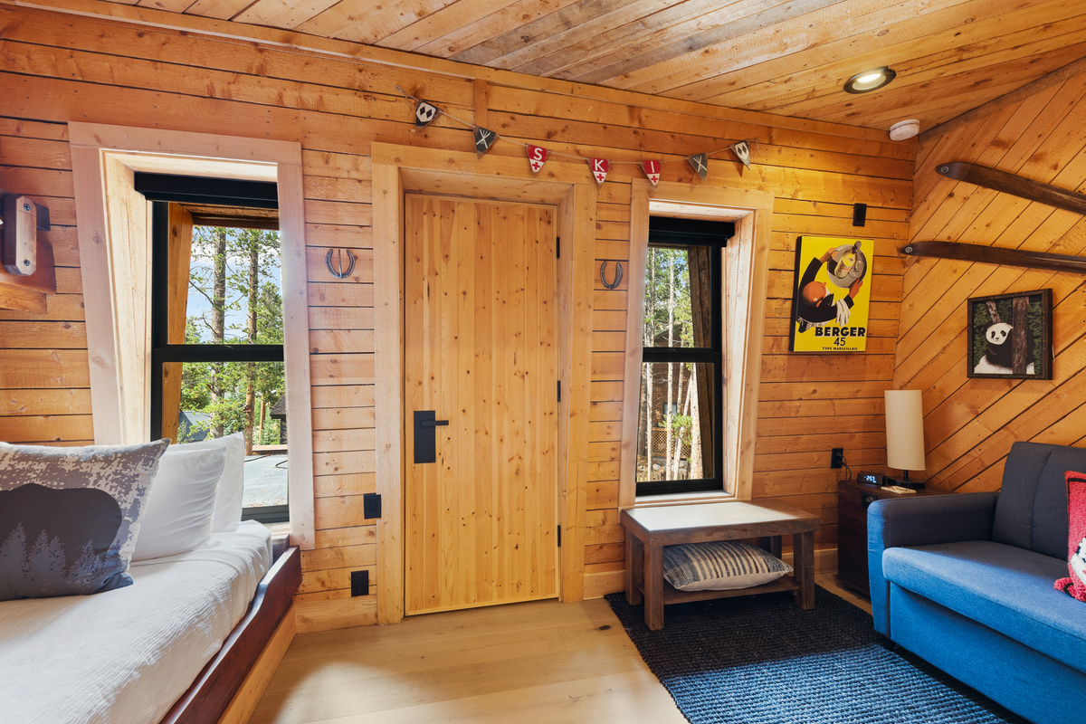 Twin-over-Queen bunk room with twin sleeper. Bunk bed is on left, twin sleeper on right. This room can sleep up to four. Door in center is a walk-in closet (does not open to a balcony or outdoor space). 