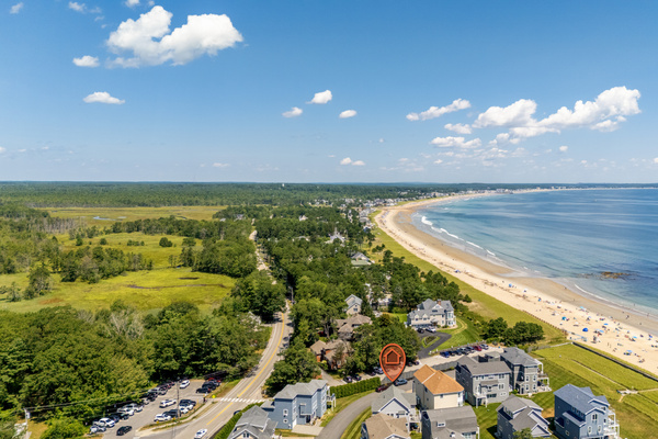A breathtaking aerial view highlights the home's location near a long stretch of sandy beach and ocean.