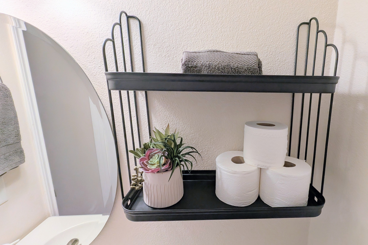 Half bath has plenty of toilet paper, hand soap, fresh towels, and a step stool for children.