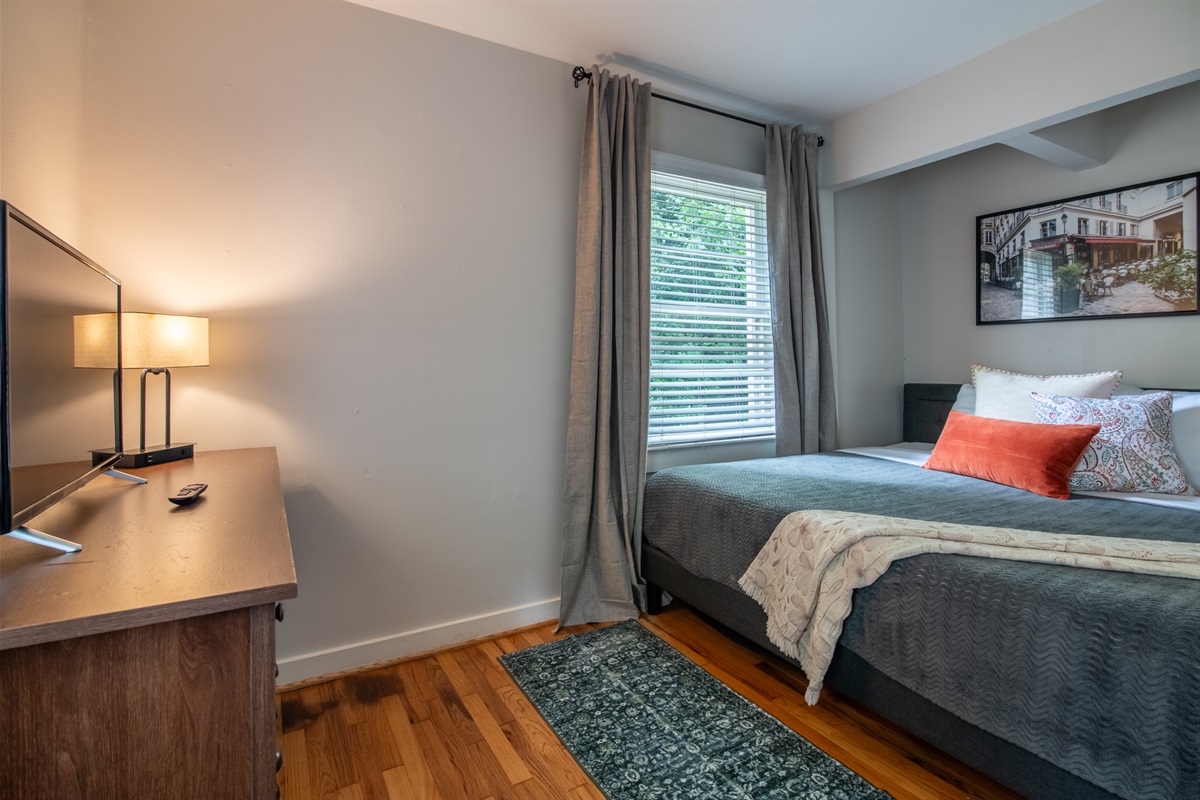 Another view of the main bedroom, showcasing large windows and soft lighting.