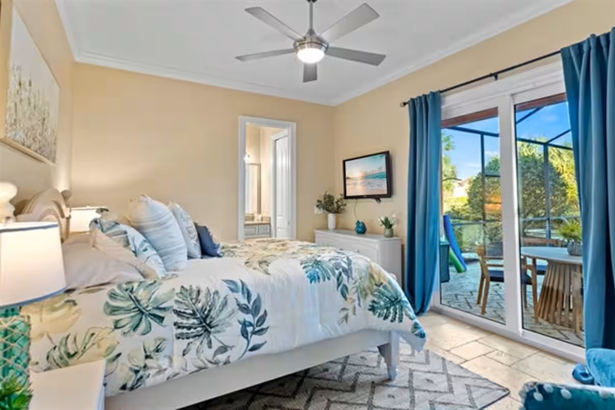 Wake up steps from your private pool 🌴
This serene bedroom features a plush bed, calming coastal décor, and sliding doors that open directly to the screened pool and spa.
