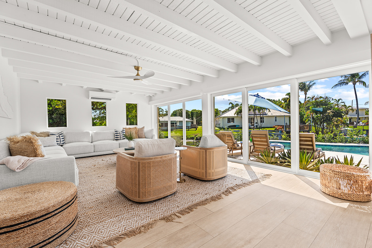 🌴 Indoor comfort meets tropical outdoor living with beautiful backyard views.