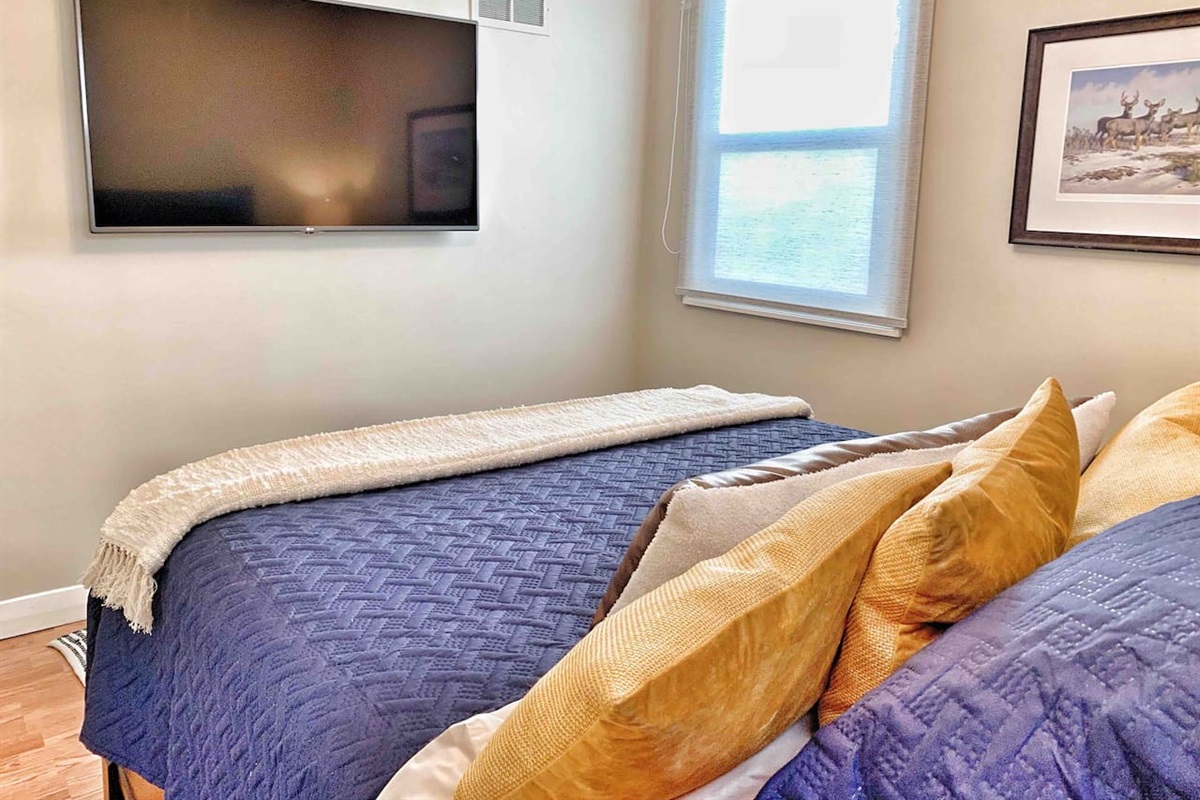 Primary Bedroom with Queen Bed & 55″ Smart TV