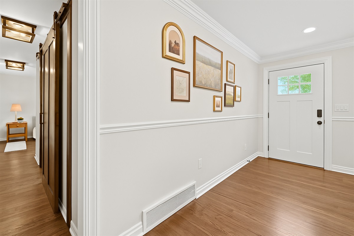 Welcoming entryway with tasteful wall art and warm wood floors, setting the tone for a cozy and stylish stay.