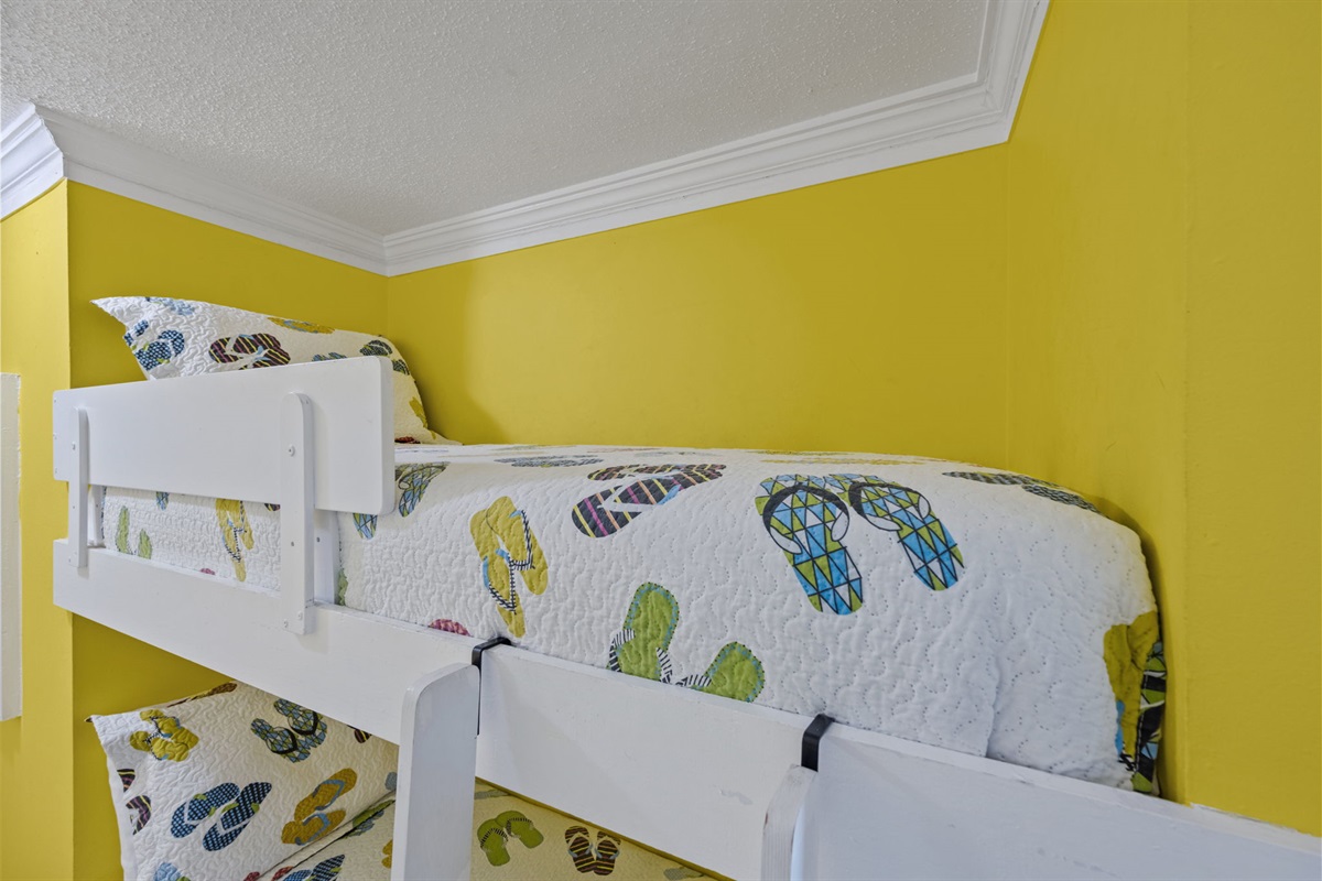 Fun bunk bed nook with bright coastal colors and playful beach-themed bedding