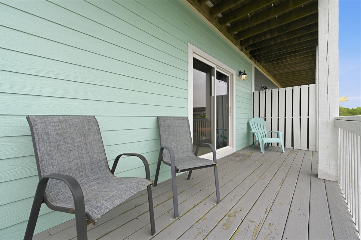 Covered deck with lounge chairs and sliding door access
