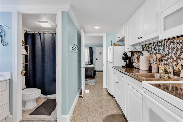 Entry hallway with bathroom on the left and kitchen on the right