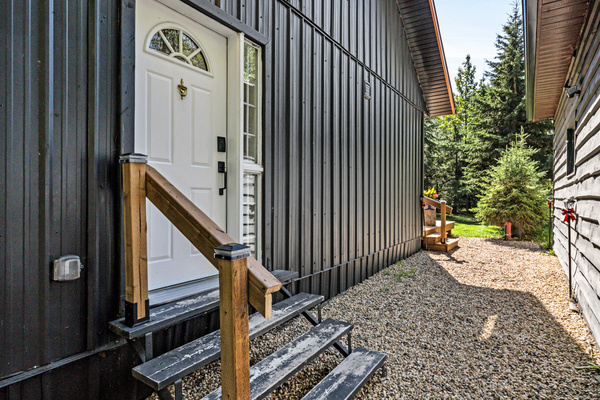 A convenient side entrance and gravel walkway make it easy to come and go while keeping the cabin connected to its outdoor spaces.
