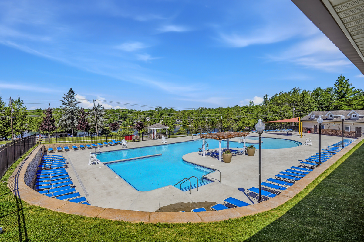 Community outdoor pool — full panoramic view with lounge chairs and open sky