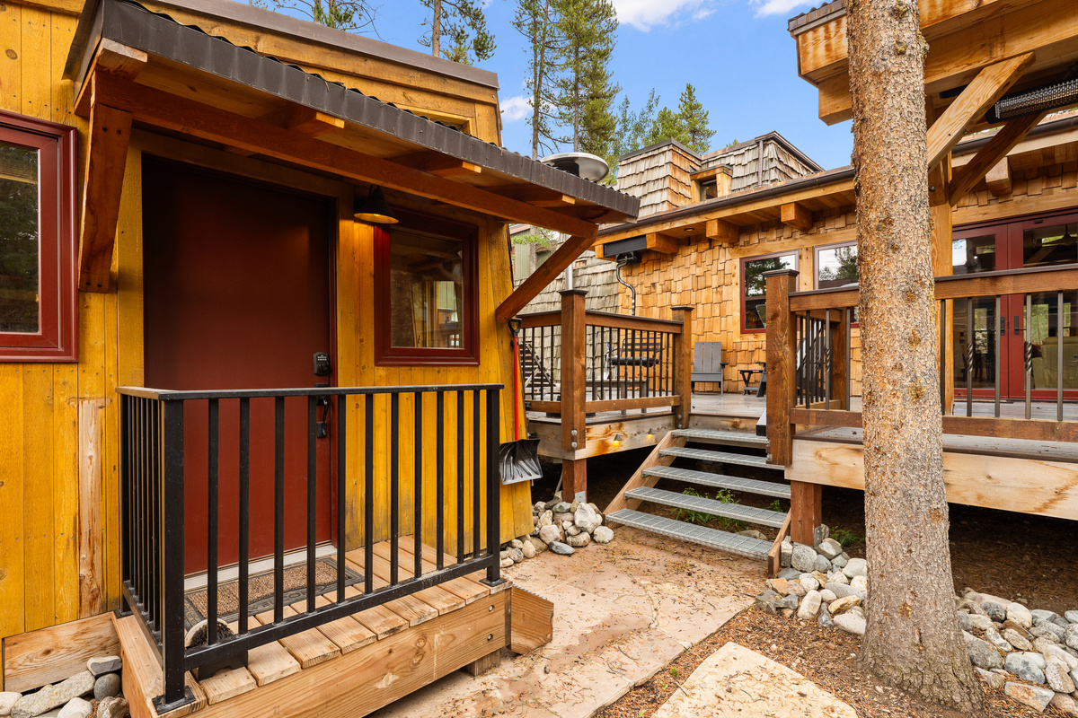 Backyard bungalow on left, outdoor living space with entrance to main house on right. 