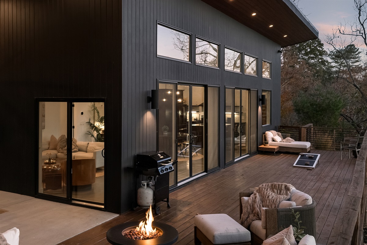 {Outdoor Lounge} The Glass House invites you to linger outside—cozy blankets, cornhole, giant Connect 4, and the forest glowing as twilight settles in. A mountain moment you won’t forget.