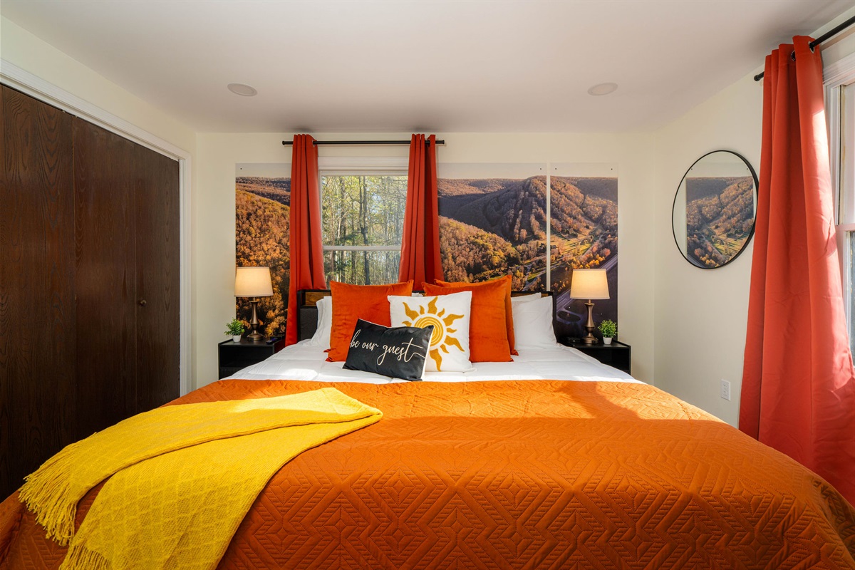 👑 The Denton Hill Sunset Room — a king bed beneath a mountain-sunset mural.