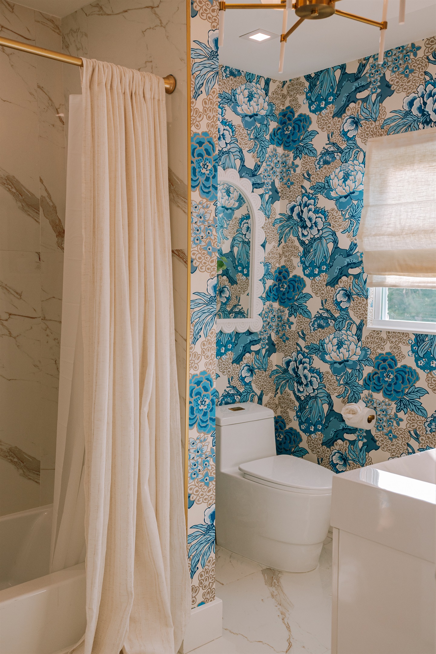 The shared full bathroom delights with colorful wallpaper and impeccable finishes.