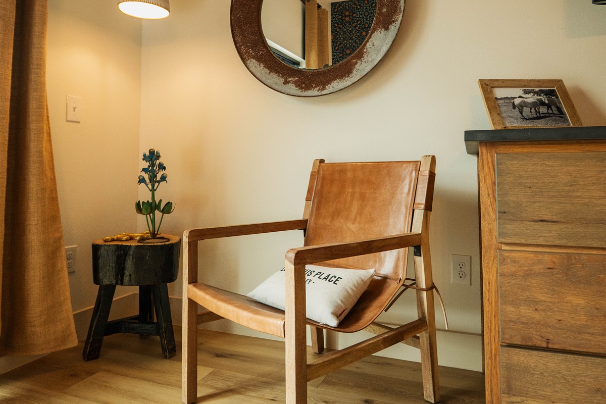 A quiet sitting nook inside the Corral Suite — a leather chair and console give you a place to land between adventures, Gaines Ranch on the Square.