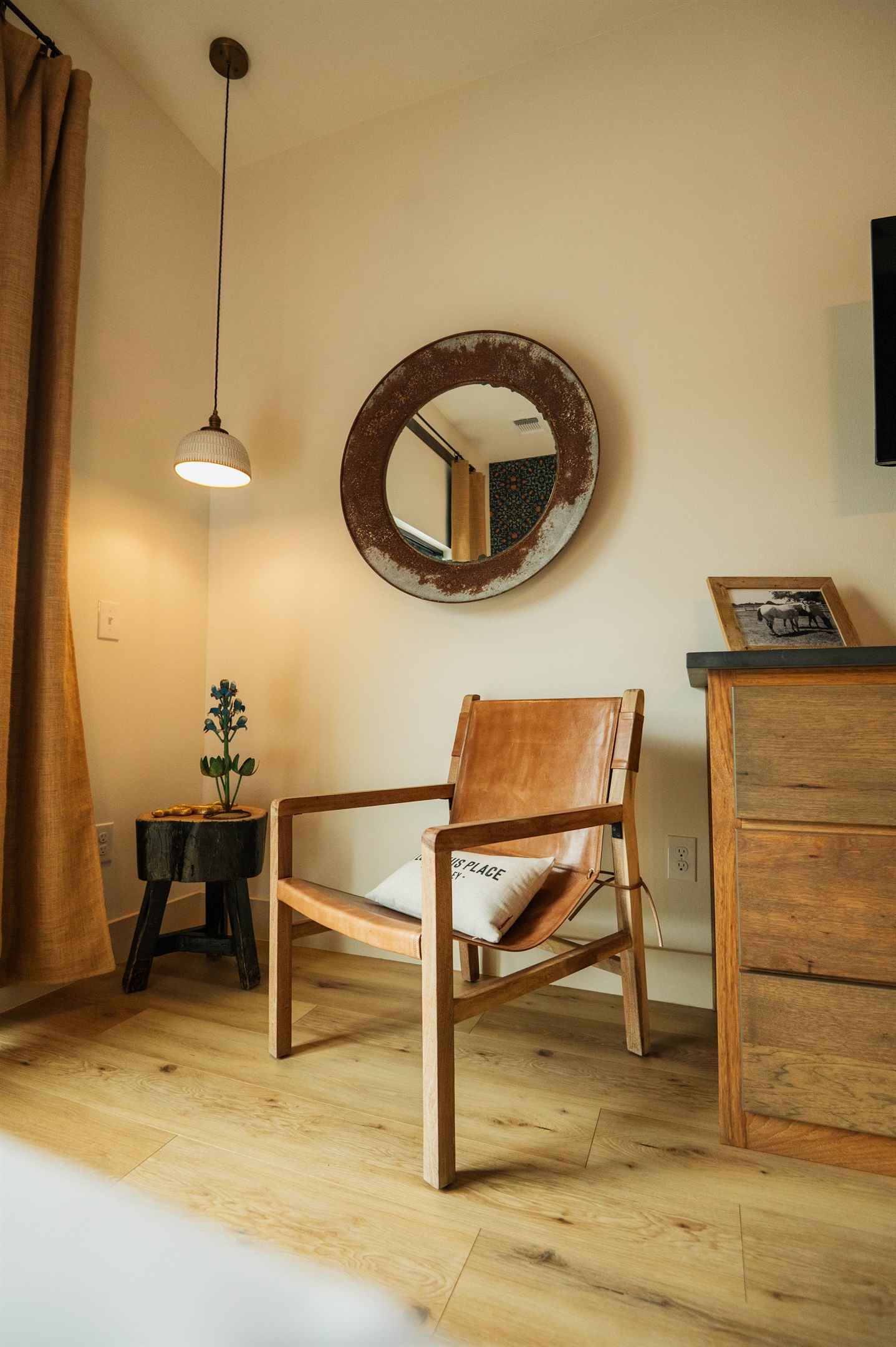 A quiet sitting nook inside the Corral Suite — a leather chair and console give you a place to land between adventures, Gaines Ranch on the Square.