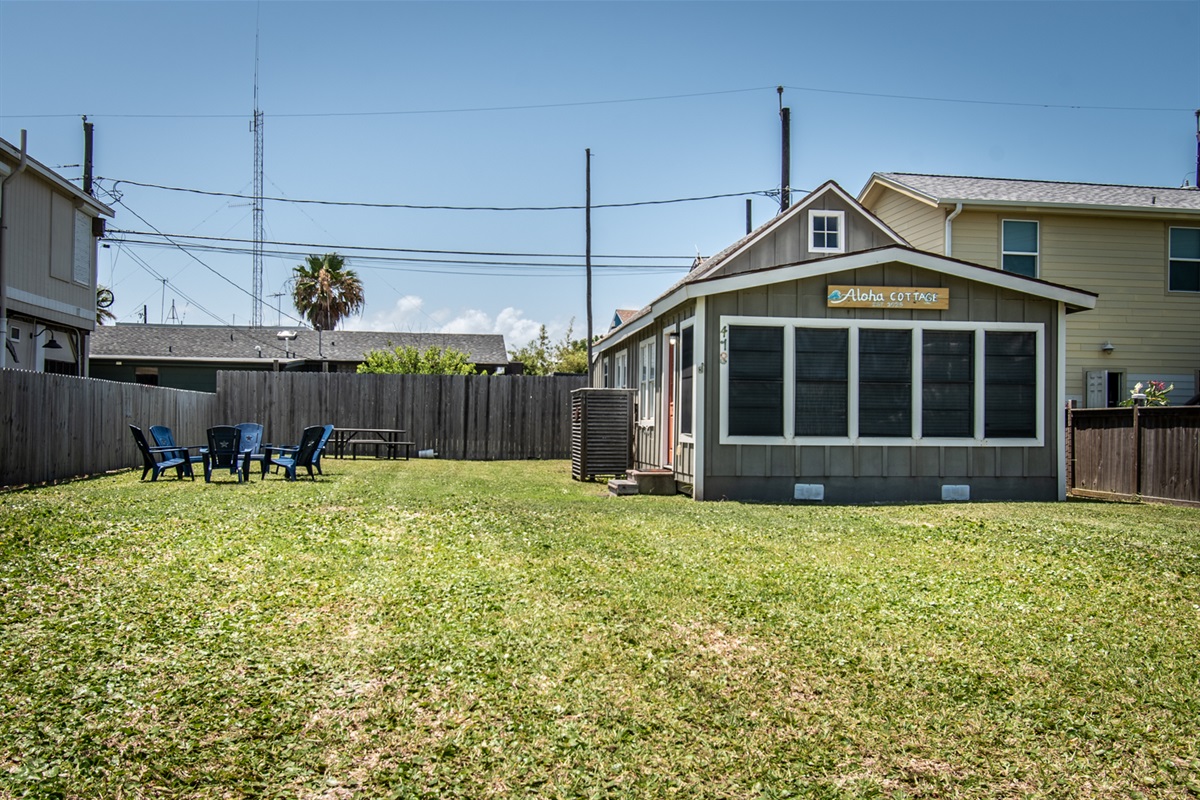 Outside of the Aloha Cottage! Picnic table, chairs, charcoal grill, outdoor shower on the back side