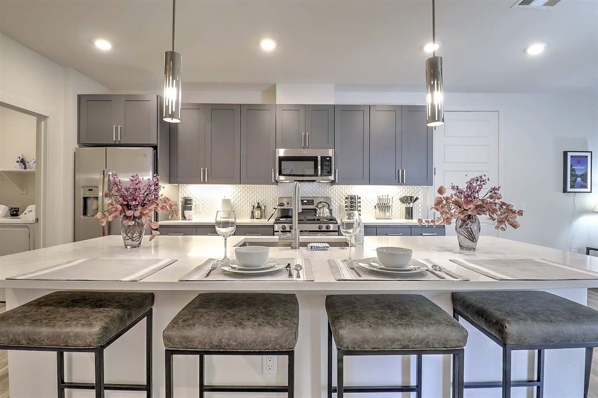 - Cook in a modern kitchen featuring stainless steel appliances and style   - Spacious island with seating is perfect for shared meals and conversations   - Elegant lighting and clean design make dining both fun and relaxing